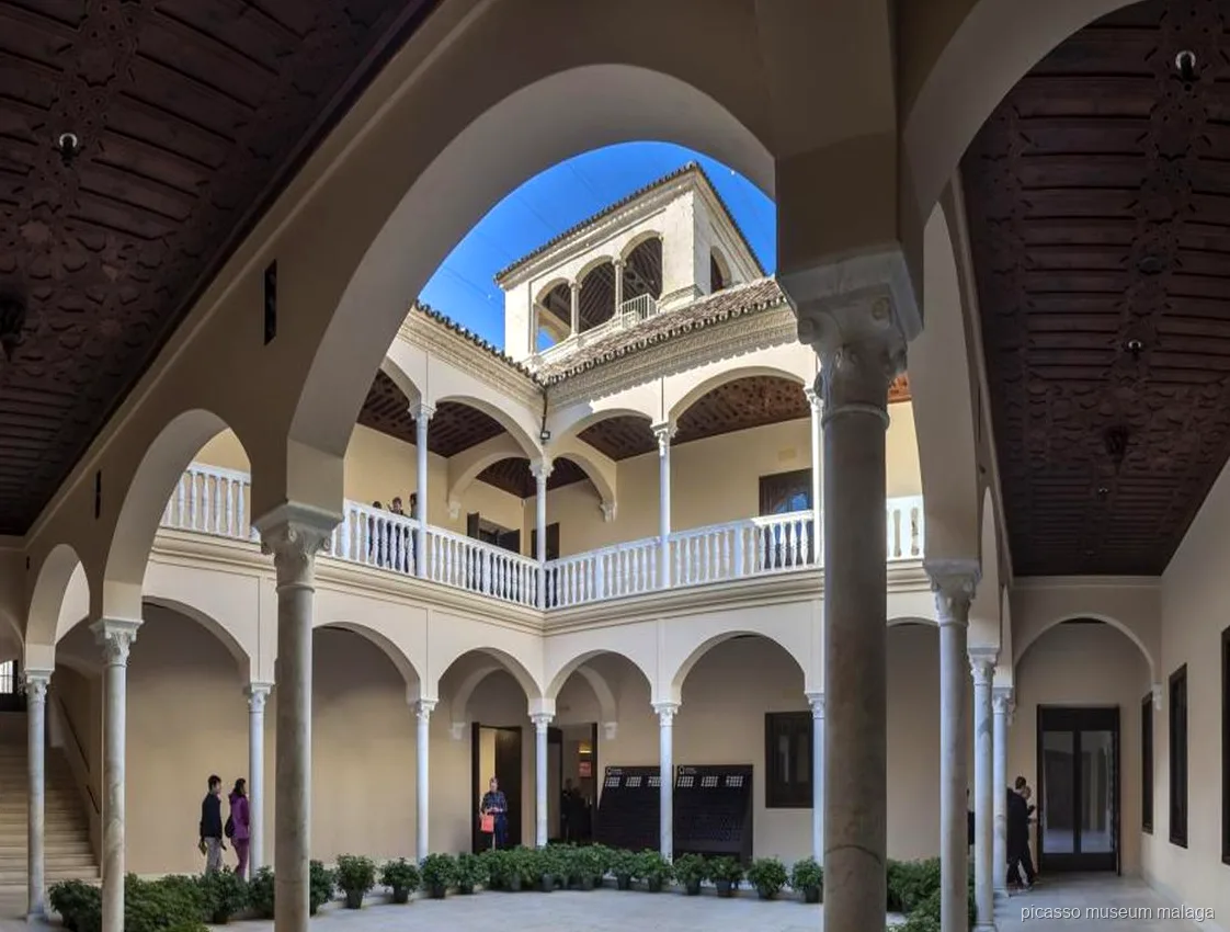 Visitantes escuchando a un guía durante una visita guiada al Museo Picasso Málaga